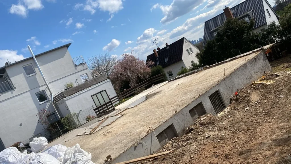 Teilweise abgebrochene Massivgarage mit freiliegender Betondecke in einem Wohngebiet