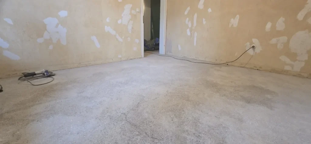 Estrichfläche nach dem Ausbau der Floor-Flex-Platten und dem Abschleifen des asbesthaltigen Klebers