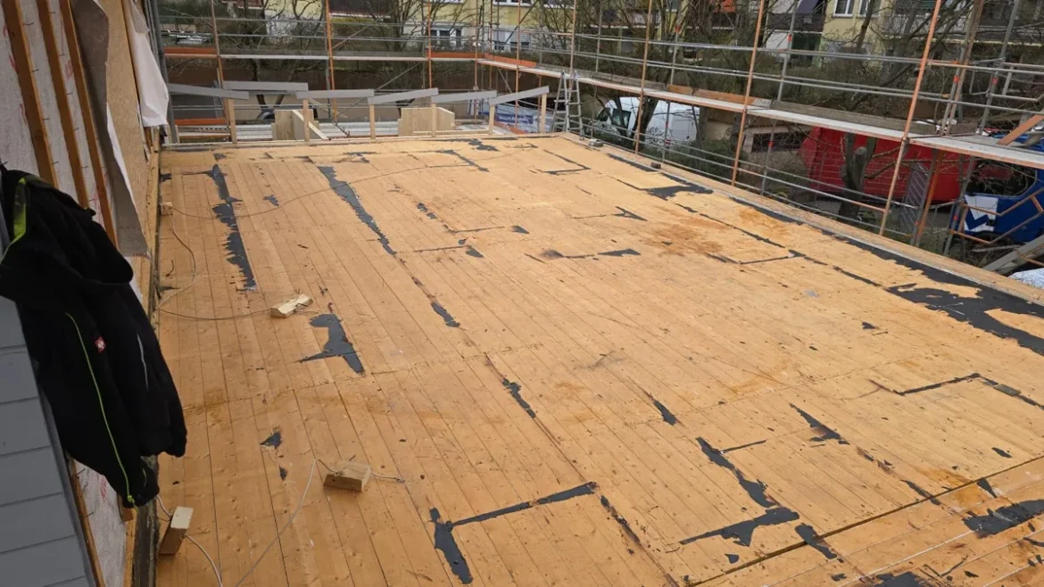 Freigelegte Holzschalung eines Flachdachs mit Resten teerhaltiger Dachbahnen