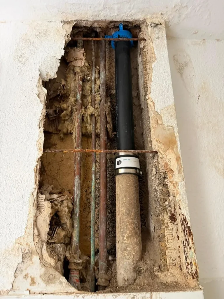 Neu eingebaute Abflussleitung mit Schlauchadapter und Rohrbelüfter im Installationsschacht